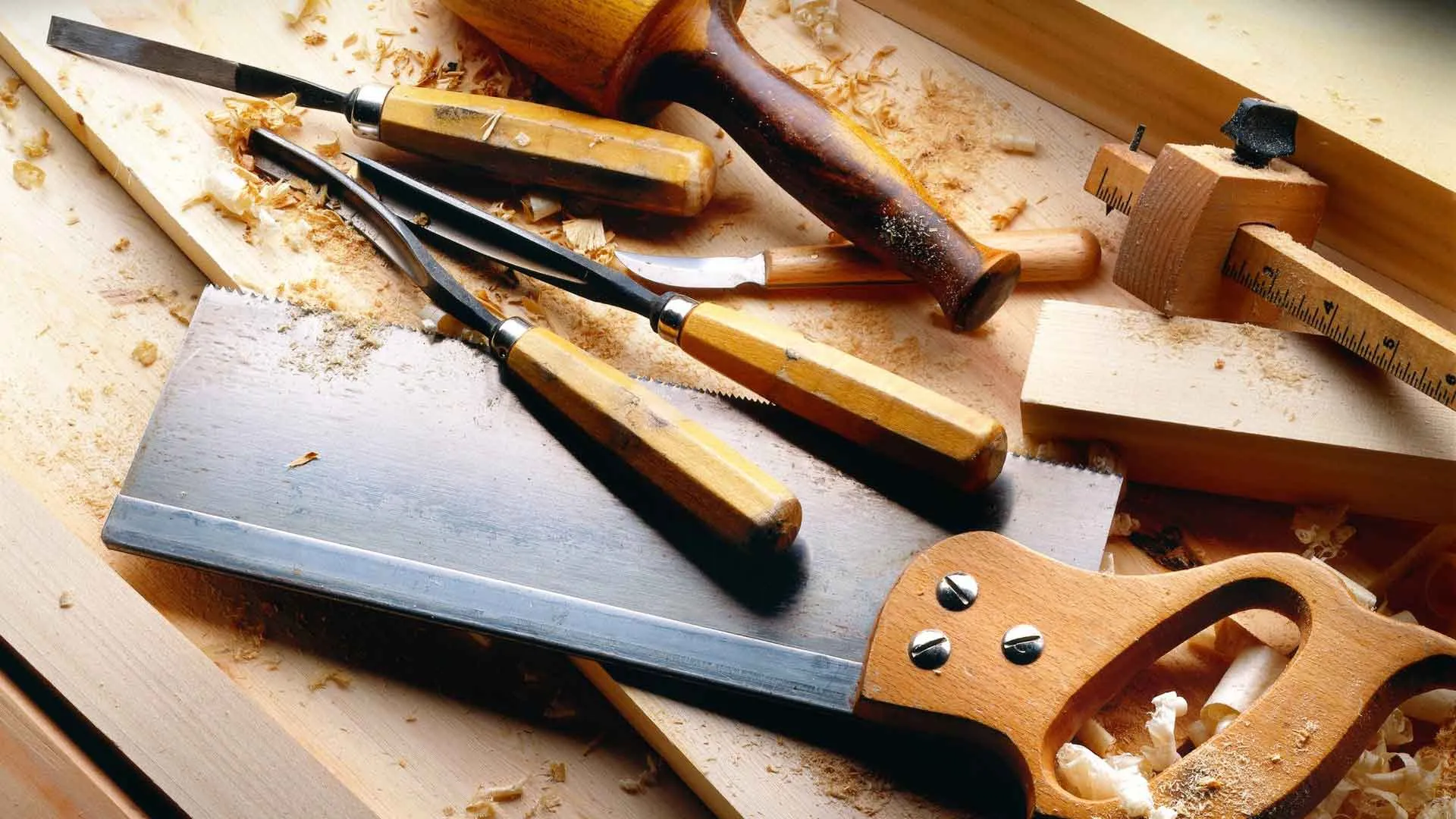 Carpenter planing an oak tabletop in a woodwork shop